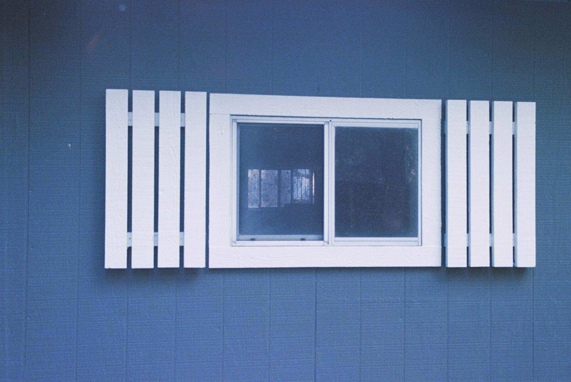 white window shutters on blue panel wall
